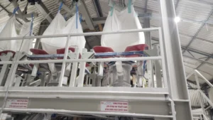 Heavy-duty bulk bag discharge station for feeding pigment powders into rotogravure ink dispersers.